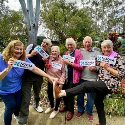 A group of elderly people holding Noosa Seniors new logo