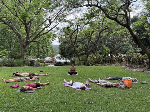 people lying down in yoga savasana in gardens
