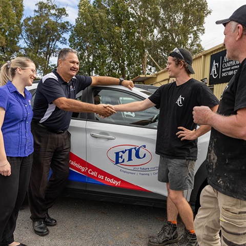 driving instructor shaking young persons hand outside of car