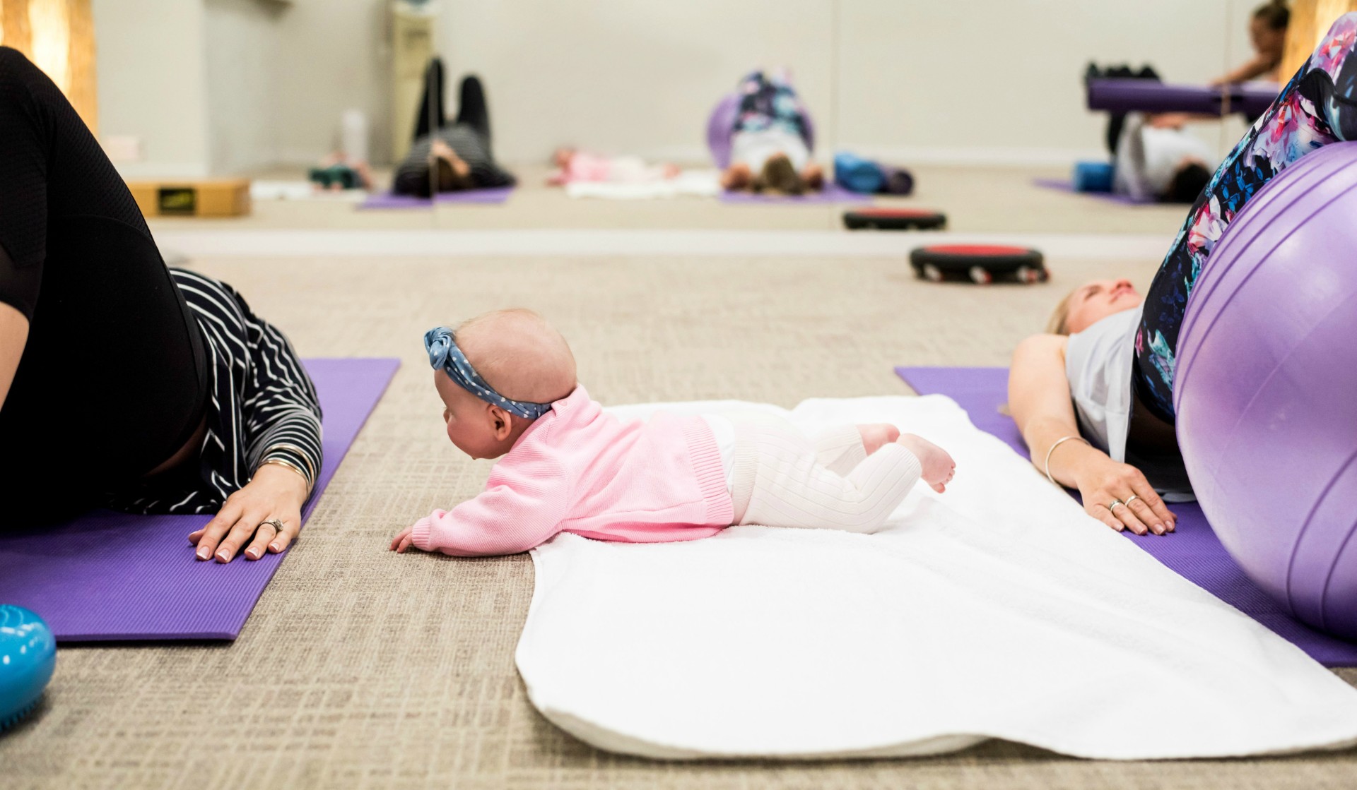 baby and mum in background exercising