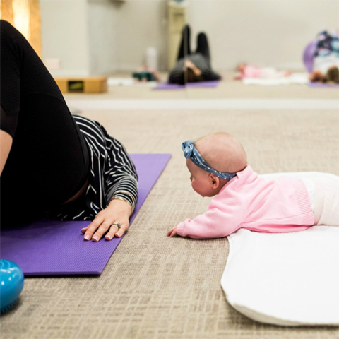 mum doing bridge exercises with baby in shot